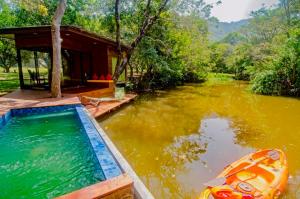 a swimming pool in the middle of a river with a house at Raintree Haven in Dambulla