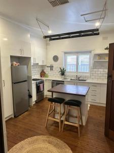 a kitchen with a table and two stools at Darlow Cottage in Wagga Wagga