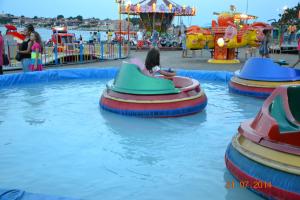a little girl riding on a ride at a water park at Nirvana Guest House in Nesebar