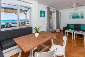 a dining room with a table and chairs and the ocean at Zodiac Apartments in Es Cana
