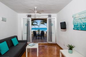 a living room with a couch and a view of the ocean at Zodiac Apartments in Es Cana