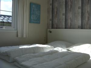 ホルムにあるChalet Zilt Amelandの窓付きの客室で、白いベッド2台が備わります。