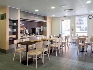 un restaurant avec des tables, des chaises et un comptoir dans l'établissement B&B HOTEL Orly Chevilly Marché International, à Chevilly-Larue