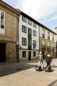 dos personas montando en segways en frente de un edificio en Pensión Rua Nova, en Santiago de Compostela