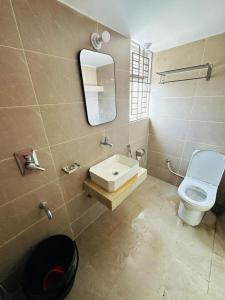 a bathroom with a sink and a toilet and a mirror at Iconic Suites in Chittagong +9 photos