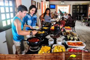 un grupo de personas de pie alrededor de una mesa con comida en Hotel Fazenda Ceu Aberto, en Gravatá