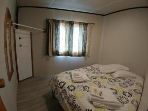 a bedroom with a bed and a window at Pine Lake View Lodge in Kaiapoi