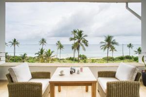 a room with a table and chairs and a view of the ocean at The Oyster Bay Hotel Suites in Dar es Salaam