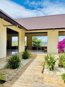 a house with a patio with purple flowers at Hoa Rừng Homestay in Xuan An