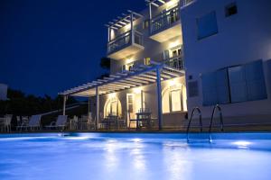 a swimming pool in front of a building at night at Anamar Blu in Ornos