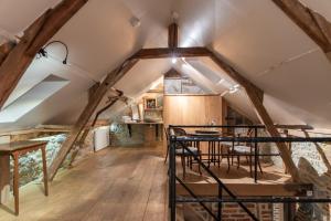 an attic kitchen with wooden floors and a ceiling with beams at B&B - Hotel Le vieux marronnier in Foy-Notre-Dame