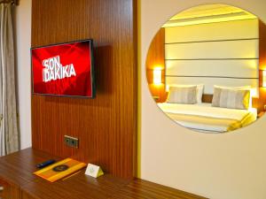 een hotelkamer met een bed en een spiegel bij Safa Royal Museum Hotel in Konya