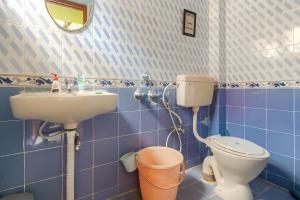 a blue tiled bathroom with a toilet and a sink at Forest View Penthouse Stay - PRIME HSR - Near NIFT in Bangalore