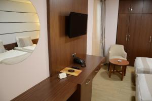 ein Hotelzimmer mit Schreibtisch, Bett und Spiegel in der Unterkunft Safa Royal Museum Hotel in Konya