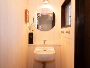 ein Badezimmer mit Waschbecken und Spiegel in der Unterkunft いけだ屋 in Kōzai + 37 Fotos