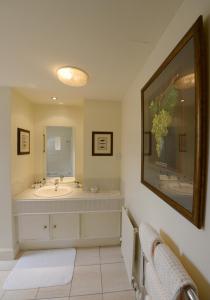baño con lavabo y espejo grande en The Factor's Inn & Factor's Cottage, en Fort William