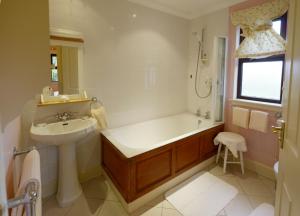a bathroom with a bath tub and a sink at The Factor's Inn & Factor's Cottage in Fort William