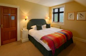 a bedroom with a large bed and a window at The Factor's Inn & Factor's Cottage in Fort William +8 photos