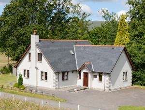 a white house with a black roof at The Factor's Inn & Factor's Cottage in Fort William