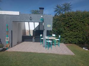 a patio with a table and chairs in a backyard at Alojamiento La Delfina in Chacras de Coria