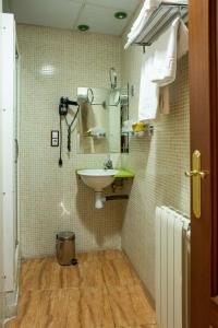 a bathroom with a sink and a toilet at Hotel Tibur in Zaragoza
