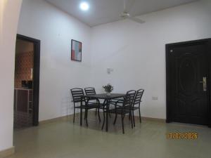 a dining room with a table and chairs in a room at Rams Lodge in Accra