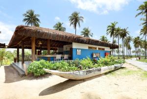 a boat on the beach in front of a building at Grand Palladium Imbassaí Resort & Spa - All Inclusive in Imbassai