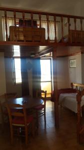 a room with a table and a bed and a table and chairs at Eleni Studios in Agios Nikolaos
