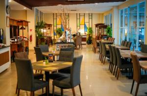 a dining room with tables and chairs in a restaurant at Patra Dumai Hotel in Dumai