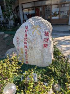 a large rock with writing on it in front of a building at Golden Dragon Hotel in Houlong