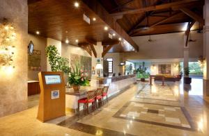 a lobby with a table and chairs in a building at Grand Palladium Imbassaí Resort & Spa - All Inclusive in Imbassai