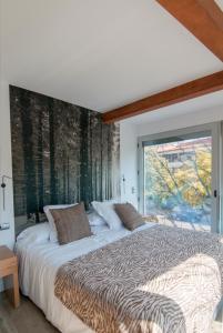 a bedroom with a large bed with a large window at Cal Tonarro in Organyà