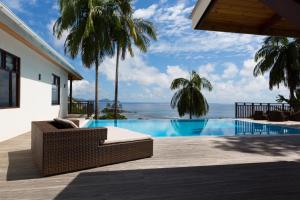 a resort with a swimming pool with a view of the ocean at Villas Palm Royal in Port Glaud