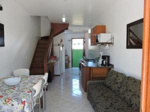 a kitchen and a living room with a couch and a table at Castelo da Ilha in Florianópolis