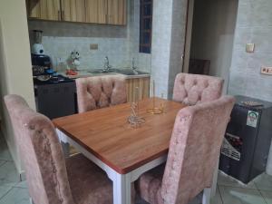 a kitchen with a wooden table with chairs around it at Texas Apartments 1 Bedroom bnb Thika in Thika