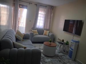 a living room with two couches and a flat screen tv at Texas Apartments 1 Bedroom bnb Thika in Thika