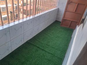 a balcony with green flooring in a building at Texas Apartments 1 Bedroom bnb Thika in Thika