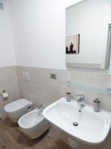 a bathroom with a sink and a toilet and a mirror at Giravento in Borgo San Dalmazzo