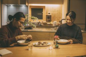 a man and woman sitting at a table eating food at Peanuts Nest in Nagano +69 photos