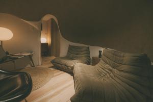 a living room with a couch and a chair at Peanuts Nest in Nagano