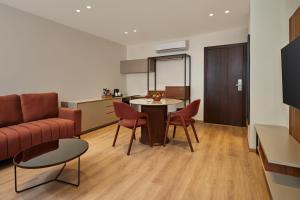 a living room with a couch and a table and chairs at Varay Grande in Ujjain