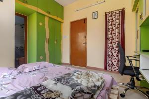 a bedroom with a bed and a desk and a chair at Forest View Penthouse Stay - PRIME HSR - Near NIFT in Bangalore