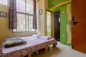 a bedroom with a bed in a room with green walls at Forest View Penthouse Stay - PRIME HSR - Near NIFT in Bangalore