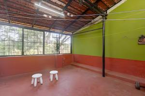 an empty room with two white stools in a room at Forest View Penthouse Stay - PRIME HSR - Near NIFT in Bangalore +2 photos
