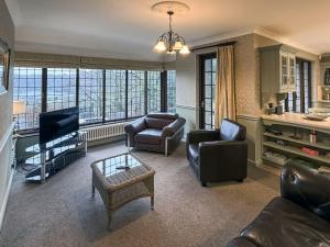 a living room with a couch and chairs and a tv at High Biggin in Windermere
