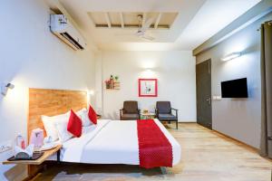 a hotel room with a bed and a tv at Hotel Wedlock Grand Suites Gurgaon in Gurgaon