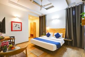 a hotel room with a bed and a table at Hotel Wedlock Grand Suites Gurgaon in Gurgaon