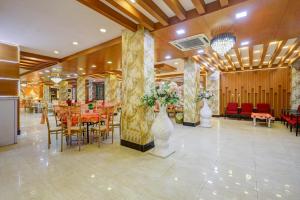 a dining room with tables and chairs and vases with flowers at Hotel Wedlock Grand Suites Gurgaon in Gurgaon