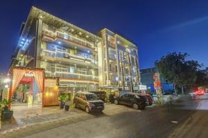 two cars parked in front of a building at night at Hotel Wedlock Grand Suites Gurgaon in Gurgaon