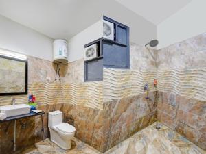 a bathroom with a toilet and a sink at Hotel Wedlock Grand Suites Gurgaon in Gurgaon +52 photos